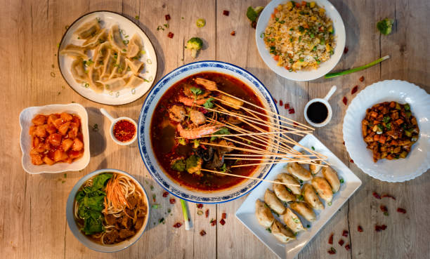 Different Chinese traditional dishes on the table, hotpot, dumplings, fried rice and beef noodle soup stock photo