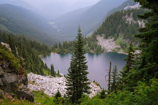 Alpine lake surrounded by trees and granite rock along the pct in Scenic, Washington, United States