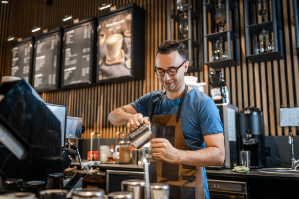 バーでお客様のためにコーヒーを入れる男性バリスタ - コーヒーショップ ストックフォトと画像