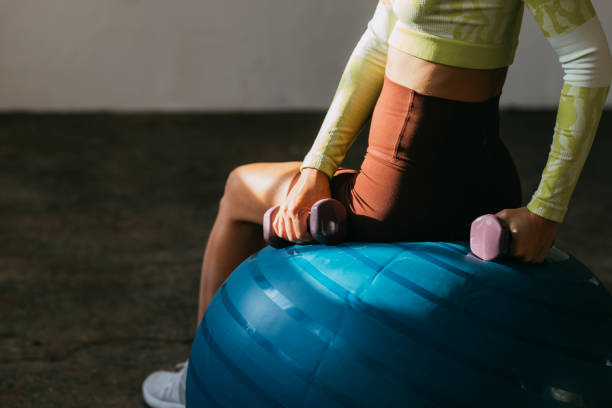 istock An Anonymous Woman Exercising with Hand Weights in Gym 1342124357