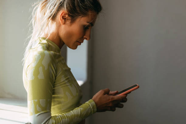 istock Serious Woman Using Mobile Phone in Gym 1342124437