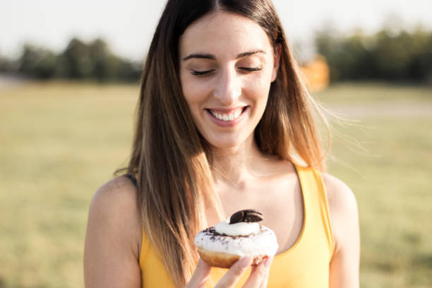 istock Happy woman holding donuts 1342124786