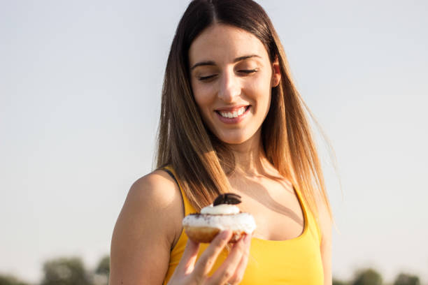 istock Happy woman holding donuts 1342124826