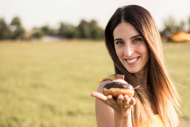 istock Happy woman holding donuts 1342125404
