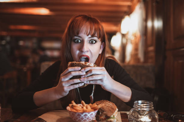istock Hungry Female Eating Burger For Dinner In Restaurant 1342125584