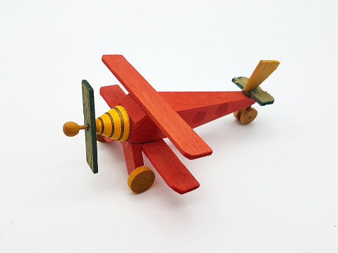 Hand made wooden toy airplane on a white background.