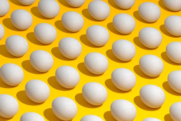 High angle view of eggs arranged on yellow background