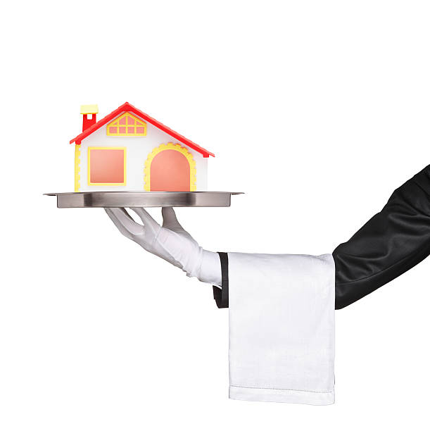 istock Waiter holding a silver tray with house model on it 134212909