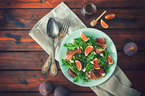 Delicious fig salad with arugula, prosciutto and goat cheese