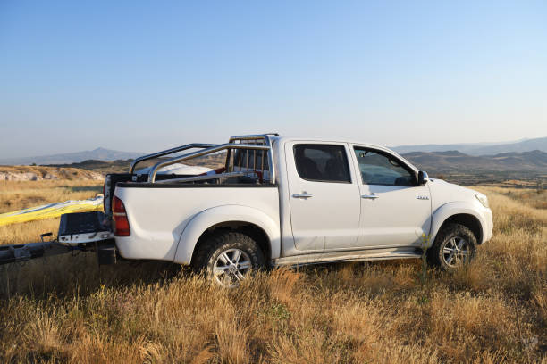 White Toyota Hilux with a trailer for a balloon basket in a field in the mountains of Cappadocia. Cappadocia, Turkey 07.12.2021: White Toyota Hilux with a trailer for a balloon basket in a field in the mountains of Cappadocia. toyota hilux stock pictures, royalty-free photos & images