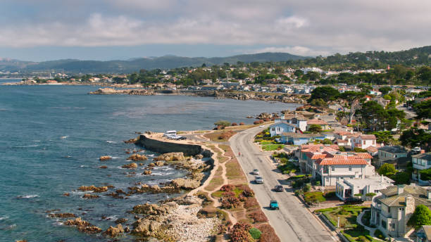 Driving Into Pacific Grove - Aerial Aerial shot of Pacific Grove, a small city in Monterey County, California. 

Shot by FAA licensed drone pilot with permit from the City of Pacific Grove. city of monterey california stock pictures, royalty-free photos & images