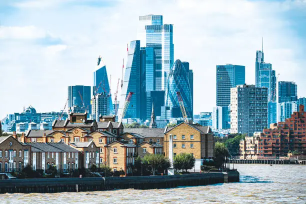 London City skyscrapers overlooking homes along River Thames