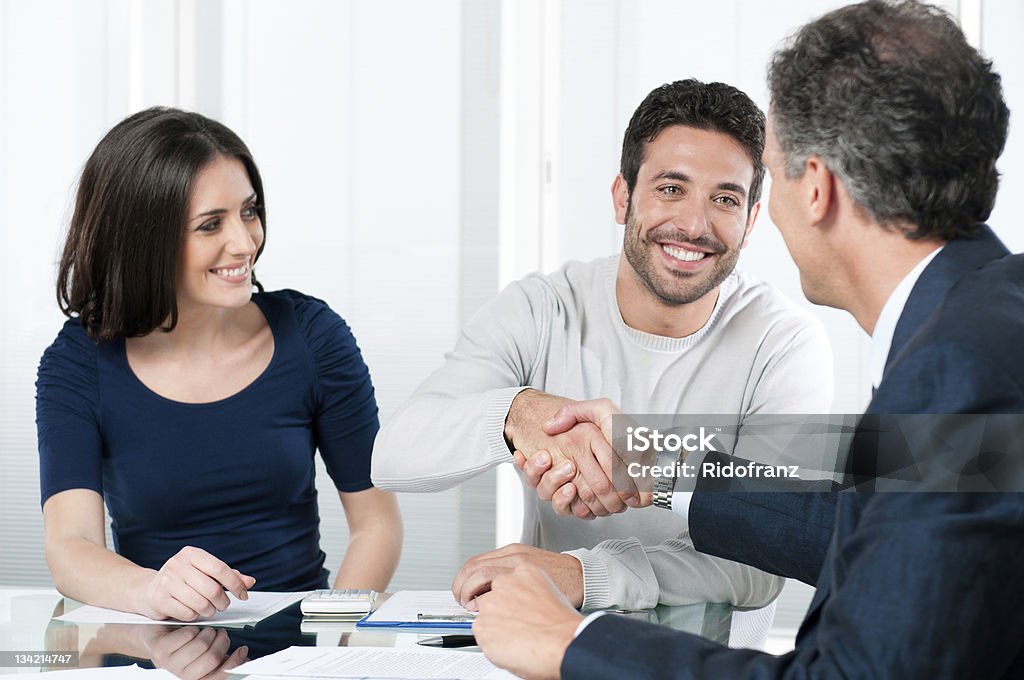 Successful financial plans Happy couple seal a deal with their personal financial advisor at home. Customer Stock Photo