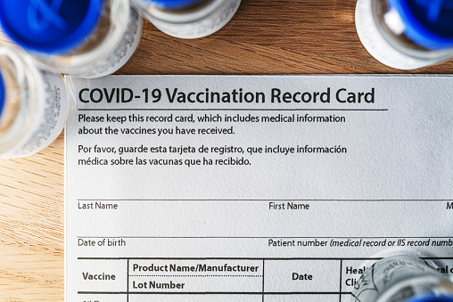 Covid-19 vaccination card, vials & syringe.