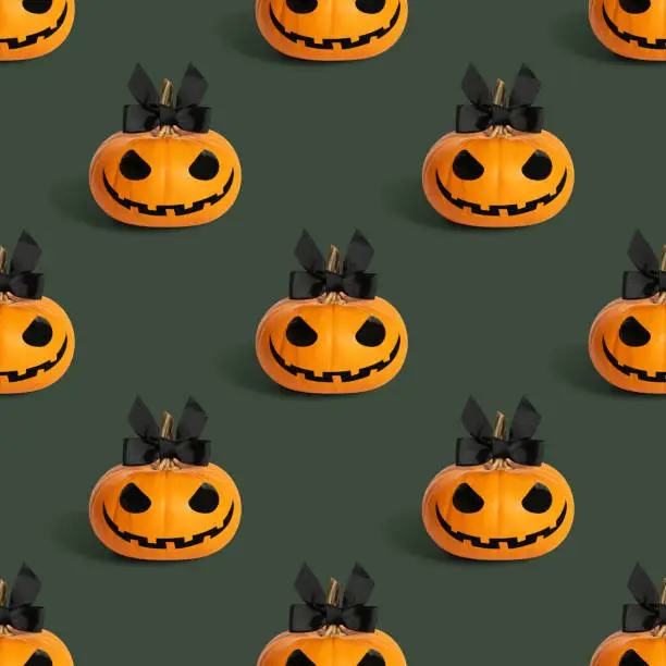 Photo of Halloween lady pumpkin seamless pattern on a green background. Jack o lantern girl background. Design for packaging.