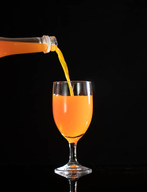istock Pour the orange syrup drink into the glass, 1342154448