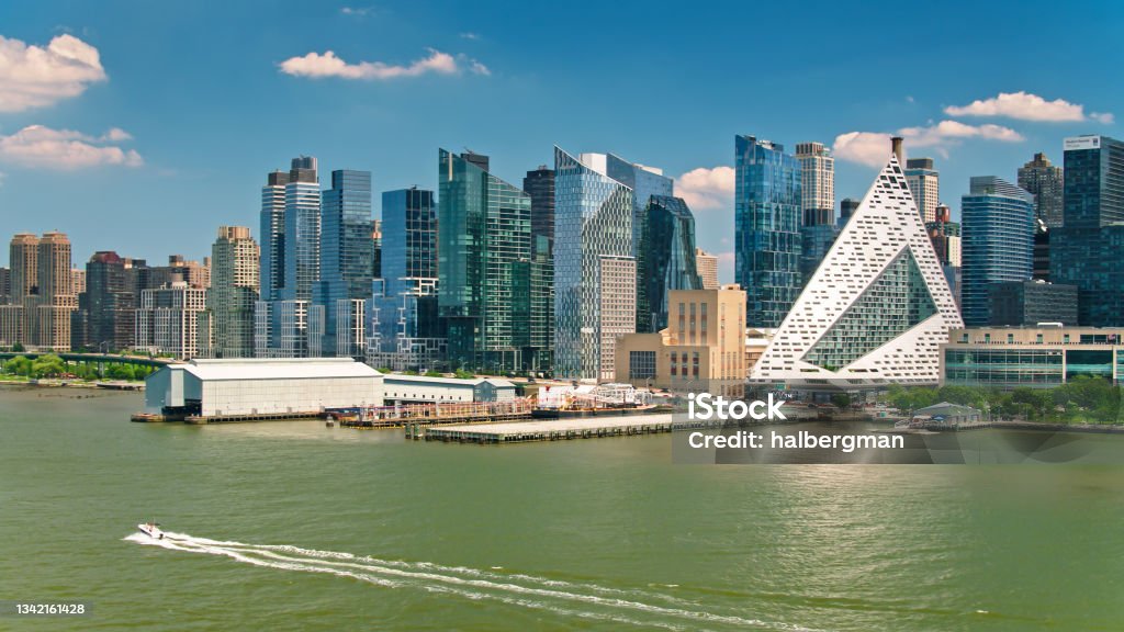 Speedboat Passing Hell's Kitchen and Upper West Side - Aerial Aerial shot of Manhattan, New York City from over the Hudson River on a sunny day in summer, looking into the Upper West Side New York City Stock Photo