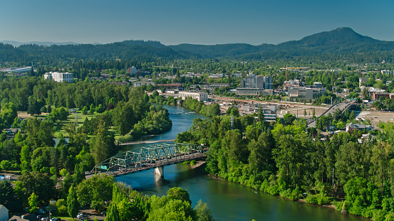 Aerial shot of Eugene, Oregon on a sunny day in summer, with the distinct shape of Spencer Butte in the distance.