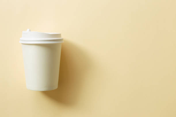 istock White paper coffee cup on beige background. top view, copy space 1342171861
