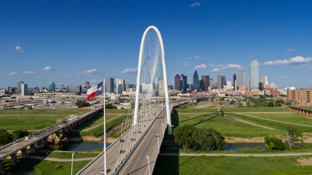 bandera del estado de texas ondeando sobre el puente margaret hunt hill con el horizonte de dallas más allá - dallas county fotografías e imágenes de stock