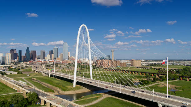 foto con drones de la bandera del estado de texas ondeando sobre el puente margaret hunt hill con el horizonte de dallas - dallas county fotografías e imágenes de stock