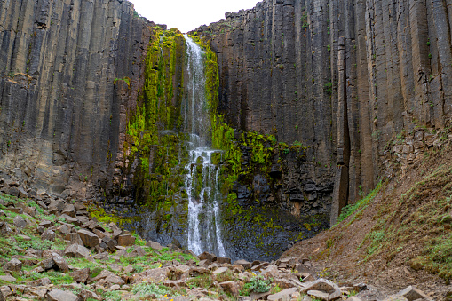 Studlafoss waterfall as welcome sign to exploders of Stuðlagil Canyon, Iceland. In background it has basalt columns as they are in Studlagil canyon.