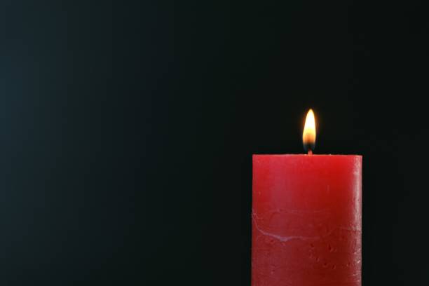 istock Red burning candle on black background.Close-up candle flame.Candle background. 1342179183