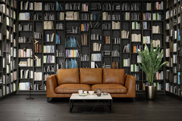 革のソファ、コーヒーテーブル、本棚の正面の景色を望む客室インテリア。 - bookstore library book bookshelf ストックフォトと画像