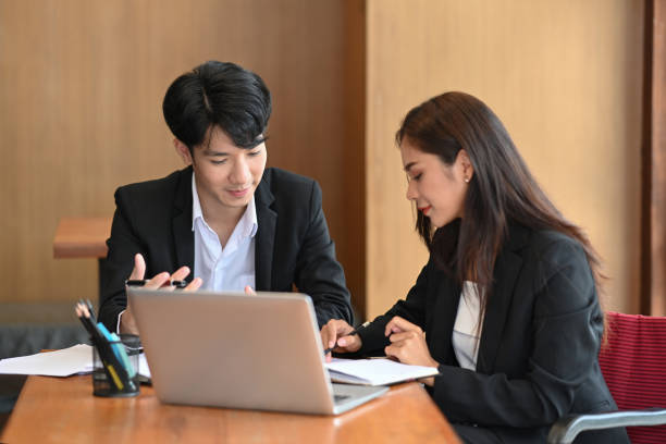istock Two successful business people checking financial reports together in office. 1342187460