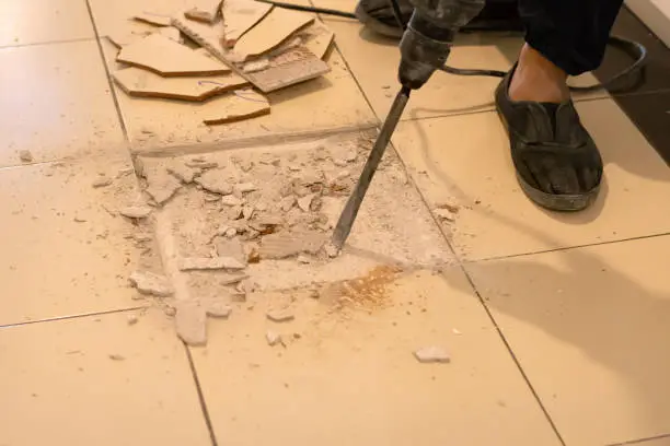 Photo of Worker are removing broken tiles for repair.