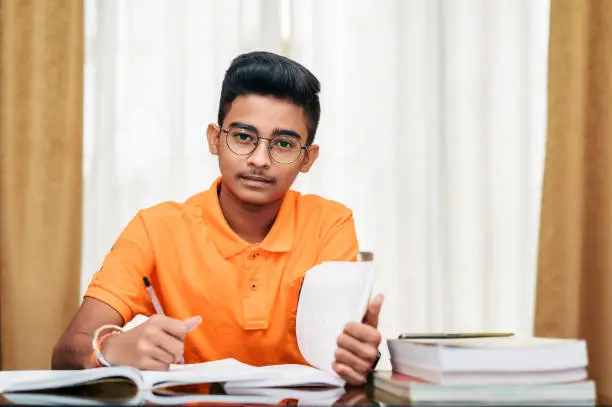 Photo of Young boy preparing for exam, Studying at home.
