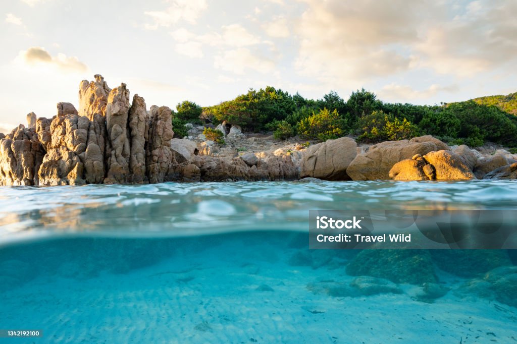 Split shot, over under photo. Half underwater with turquoise water and a rocky coast on the water surface. Prince Beach (Spiaggia del Principe) Sardinia, Italy. - Royalty-free Akdeniz Stok görsel