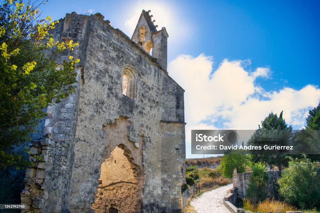 Abandoned remains of the monastery of La Armedilla XV century with sun behind the belfry, Spain Abandoned Stock Photo