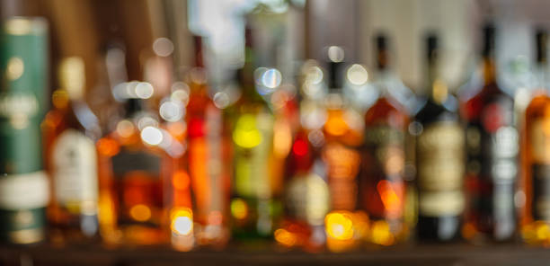 istock Beautiful bokeh from a row of alcoholic bottles in backlight. Panoramic shot. 1342192901