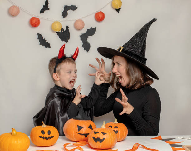 istock Mother and son have fun playing and celebrating Halloween in a witch and devil costume 1342197274