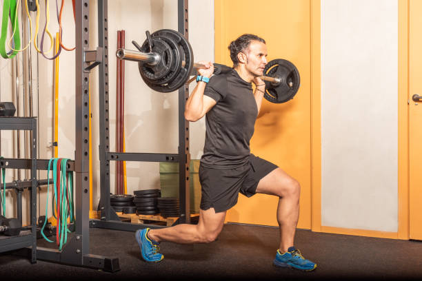 istock Man doing squats with bar at gym 1342198276