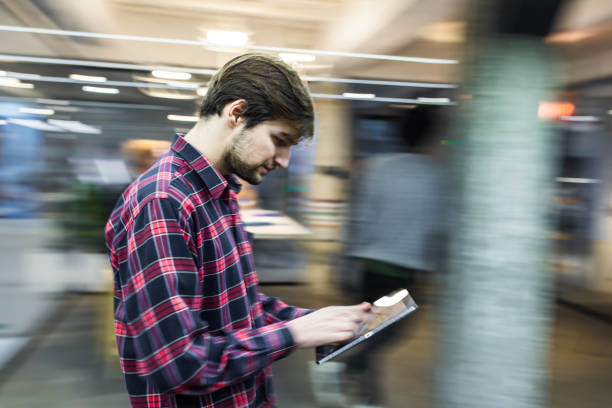 istock Young creative man using touchpad in blurred motion at casual office. 1342198443