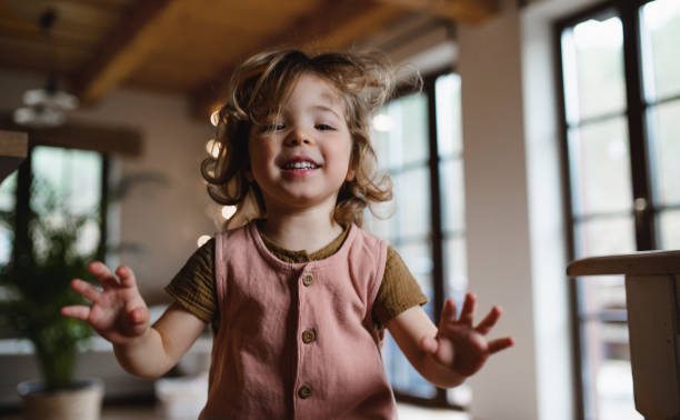 istock Happy small girl jumping at home, looking at camera. 1342199823