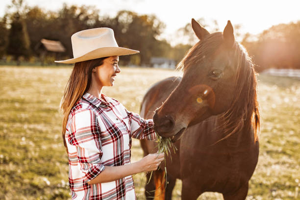 istock Happy female farmer feeding her horse on a ranch. 1342201027