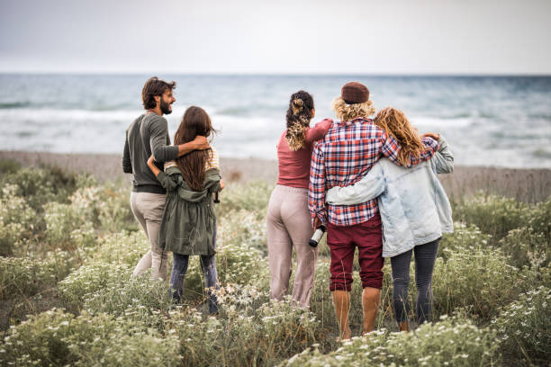 istock Back view of embraced people looking at sea view. 1342201991