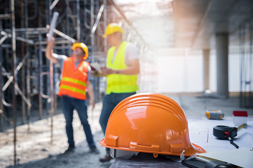 El casco de seguridad amarillo en el sitio de construcción y el concepto de seguridad de fondo del trabajador del sitio de construcción primero. photo