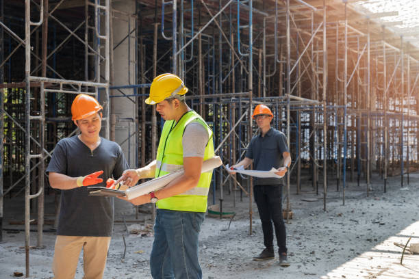 ingeniero discutiendo con capataz sobre proyecto en obra de construcción. ingeniero y arquitecto trabajando en obra con plano. - construction worker architect construction manual worker fotografías e imágenes de stock