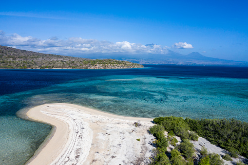 Aerial drone view of the white sand beach of Menjangan island located on the north western tip of Bali in Indonesia and facing directly Java island of its volcanoes.