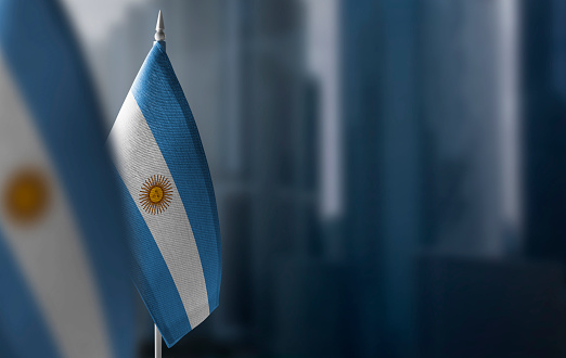 Small flags of Argentina on a blurry background of the city.