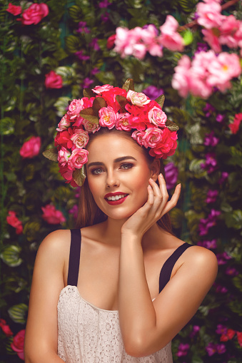 Beautiful young woman beauty and fashion portrait with wreath headband in flowers garden