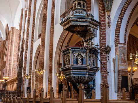Beautiful pulpit from 1609 in Roskilde Cathedral.\nRoskilde Cathedral was opened in 1175 when Denmark was still catholic. With the reformation in 1536 Denmark became protestant. Most Danish kings and queens are buried in the cathedral, which is on the UNESCO World Heritage list.