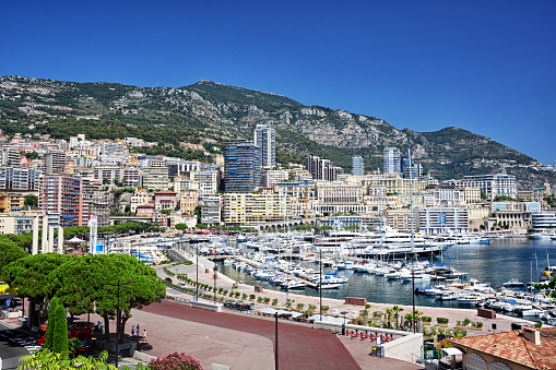 Monte Carlo Monaco - May 2 2011; Hills and intense building structures surrounding habour  with luxury super yachts.