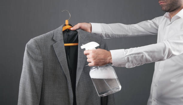 istock Man using cleaning liquid disinfectant spray in suit. 1342209244