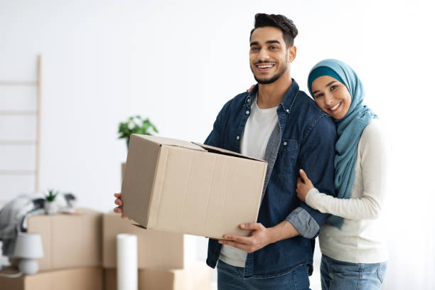 istock Pretty muslim lady hugging her husband holding paper box 1342213043