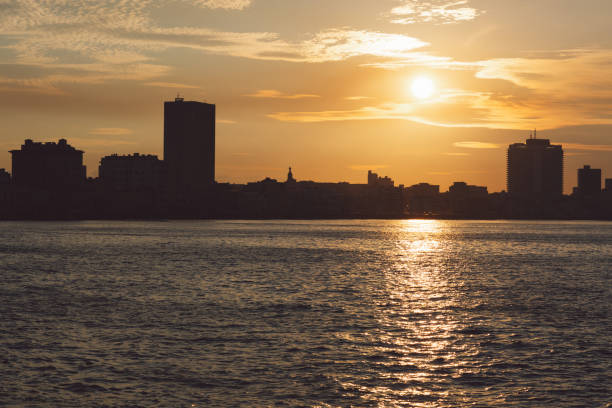 istock Silhouette Buildings By Sea Against Sky During Sunset 1342213357